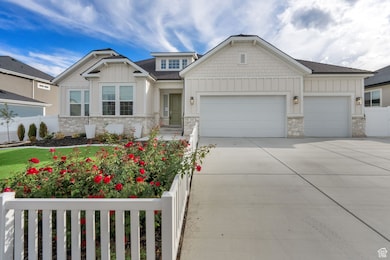 Craftsman-style home featuring board and batten siding, stone siding, a garage, and concrete driveway