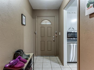 Entryway with light tile patterned floors and a te