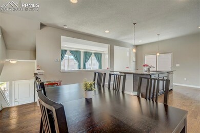 Dining area with sink, wood-type flooring, and a textured ceiling