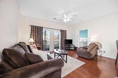 Living room with ceiling fan and dark wood-type fl