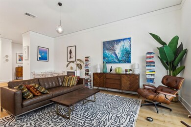 Living room with visible vents, wood finished floo