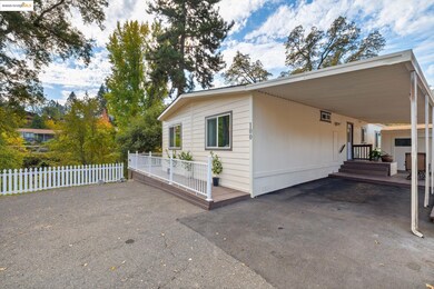 View of side of home featuring a deck, a carport, and driveway