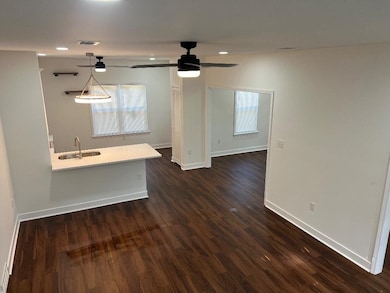 Unfurnished living room with a ceiling fan, dark wood-style floors, and recessed lighting