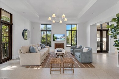 Tiled living room with french doors, a chandelier,