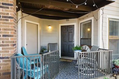 Property entrance featuring a porch and brick sid