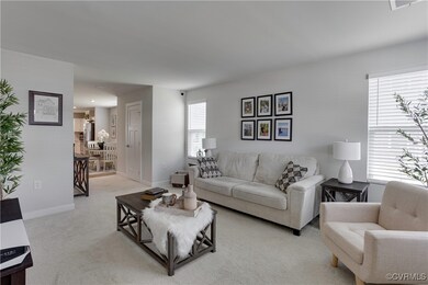 Living area with light colored carpet and baseboar