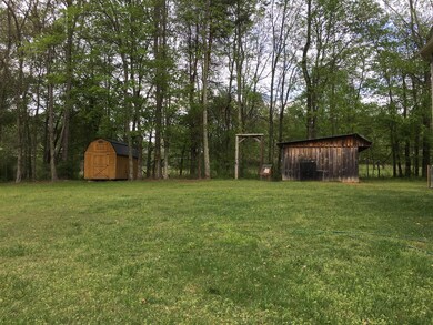 Two attractive barn type storage units in backyard.