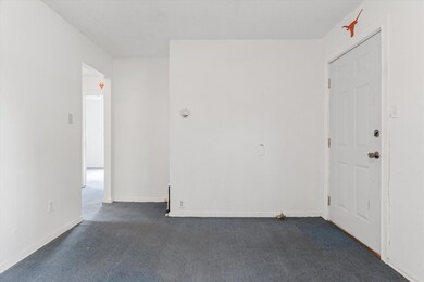 Unfurnished room with baseboards and dark carpet
