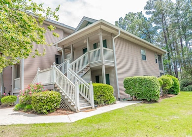 View of side of home featuring a lawn, stairway, a