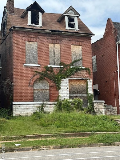View of front of home with brick siding and a chimney