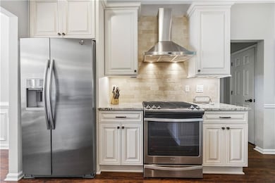 Kitchen featuring wall chimney exhaust hood, light