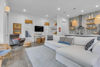 Living area with light wood-style flooring and recessed lighting