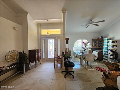 Entrance foyer with a ceiling fan, tile patterned