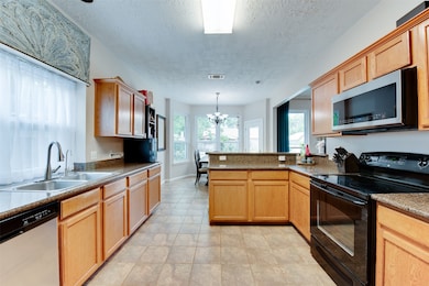 This spacious kitchen features wooden cabinetry, g