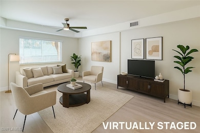 Living room featuring light wood-type flooring and a ceiling fan