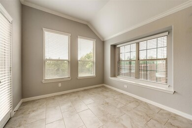 Spare room with ornamental molding and vaulted ceiling