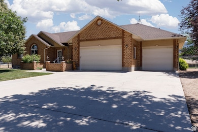 View of front of property with an attached garage, driveway, and brick siding