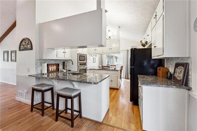 Kitchen featuring light wood-style floors, a penin