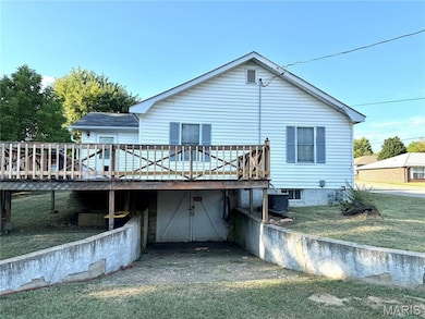 Back of property with a wooden deck and a lawn