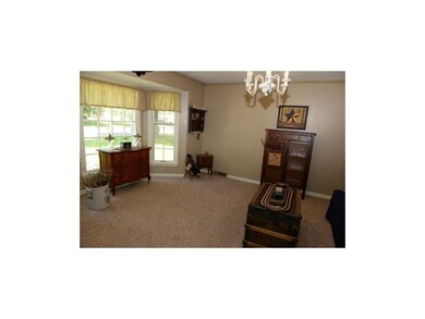 Carpeted living room with bay windows.
