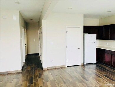 Kitchen with freestanding refrigerator, wood finish floors, and light countertops