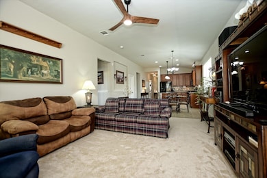 Living room with light colored carpet, a ceiling 