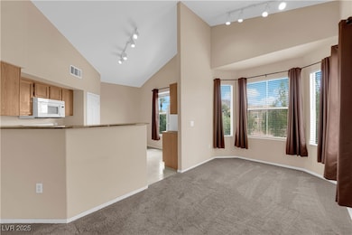 Empty room with track lighting, visible vents, bas