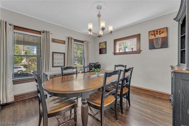Dining area featuring ornamental molding, a notable chandelier, and dark wood-type flooring