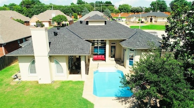 Back of property with roof with shingles, stucco siding, a chimney, a residential view, and a patio area