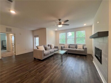 Living area with dark wood finished floors, healthy amount of natural light, a ceiling fan, a fireplace, and recessed lighting