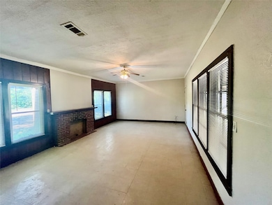 Living room with light floors, crown molding, a textured ceiling, ceiling fan, and a fireplace
