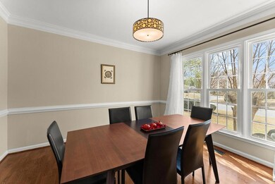 Dining room featuring baseboards, ornamental molding, wood finished floors, and plenty of natural light