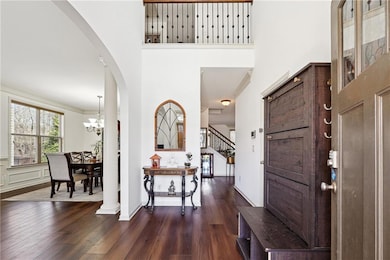 Entrance foyer featuring arched walkways, dark woo