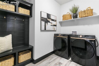 Laundry area featuring light wood finished floors and washing machine and clothes dryer