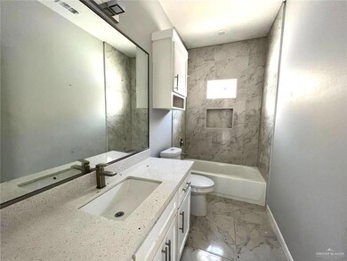 Full bath with marble look tiles, vanity, and bathing tub / shower combination