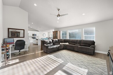 Living room featuring a desk, lofted ceiling, recessed lighting, wood finished floors, and a ceiling fan