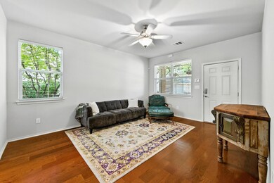 Living area featuring a ceiling fan and dark wood