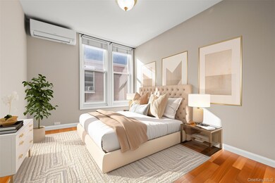 Bedroom with light wood-style flooring and a wall unit AC