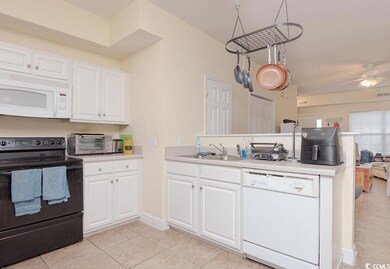 Kitchen featuring white appliances, light tile pat