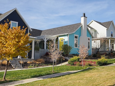 View of front facade featuring a chimney, a front lawn, a shingled roof, and a porch