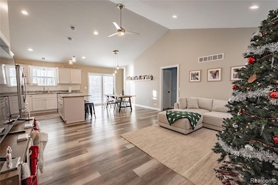 Living room featuring high vaulted ceiling, light wood-style flooring, a ceiling fan, and recessed lighting