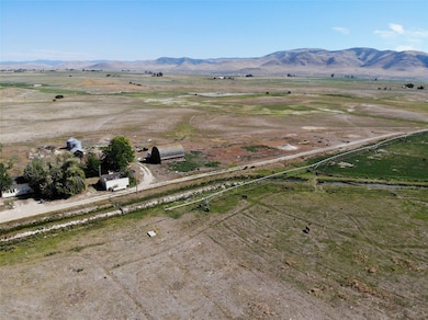 Aerial view of property and surrounding area featuring rural landscape and mountains