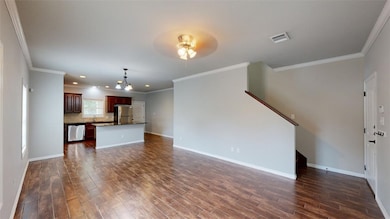 Unfurnished living room with ornamental molding, dark wood-style flooring, a chandelier, recessed lighting, and a ceiling fan