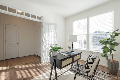 Home office with light wood-type flooring and a he