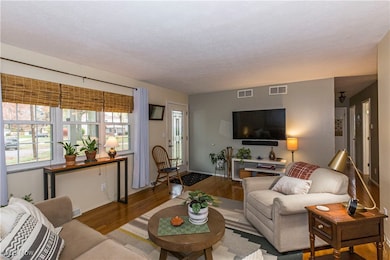 Living room with wood finished floors and a textured ceiling