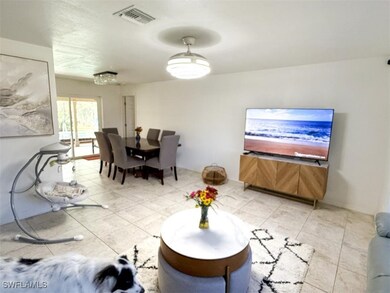 Living room with visible vents and light tile patt
