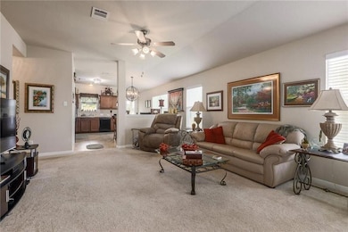 Living room featuring light colored carpet and a ceiling fan