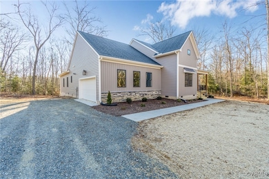 View of side of property with a garage, a shingled