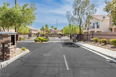 View of asphalt road with a gate, curbs, a gated e