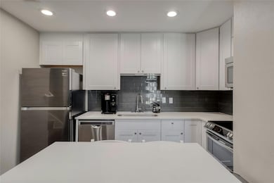 Kitchen featuring decorative backsplash, white ca